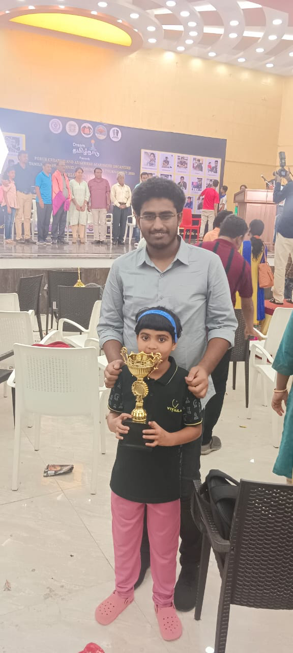 A young student holding a trophy at a prize-giving