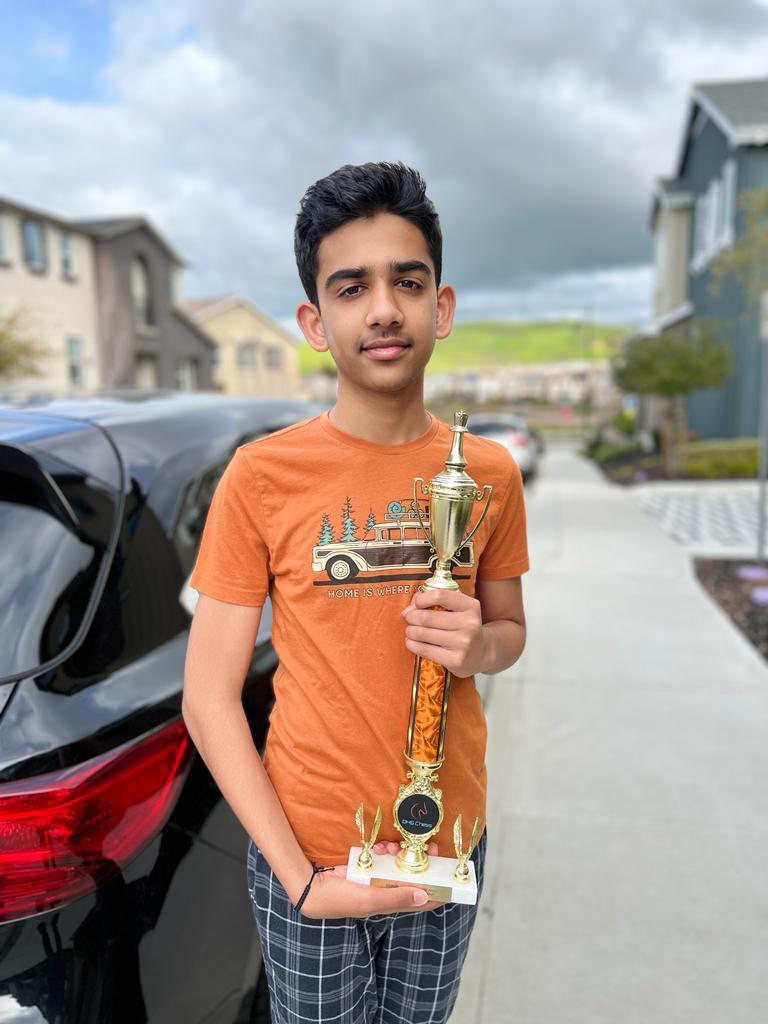 A student holding his chess trophy